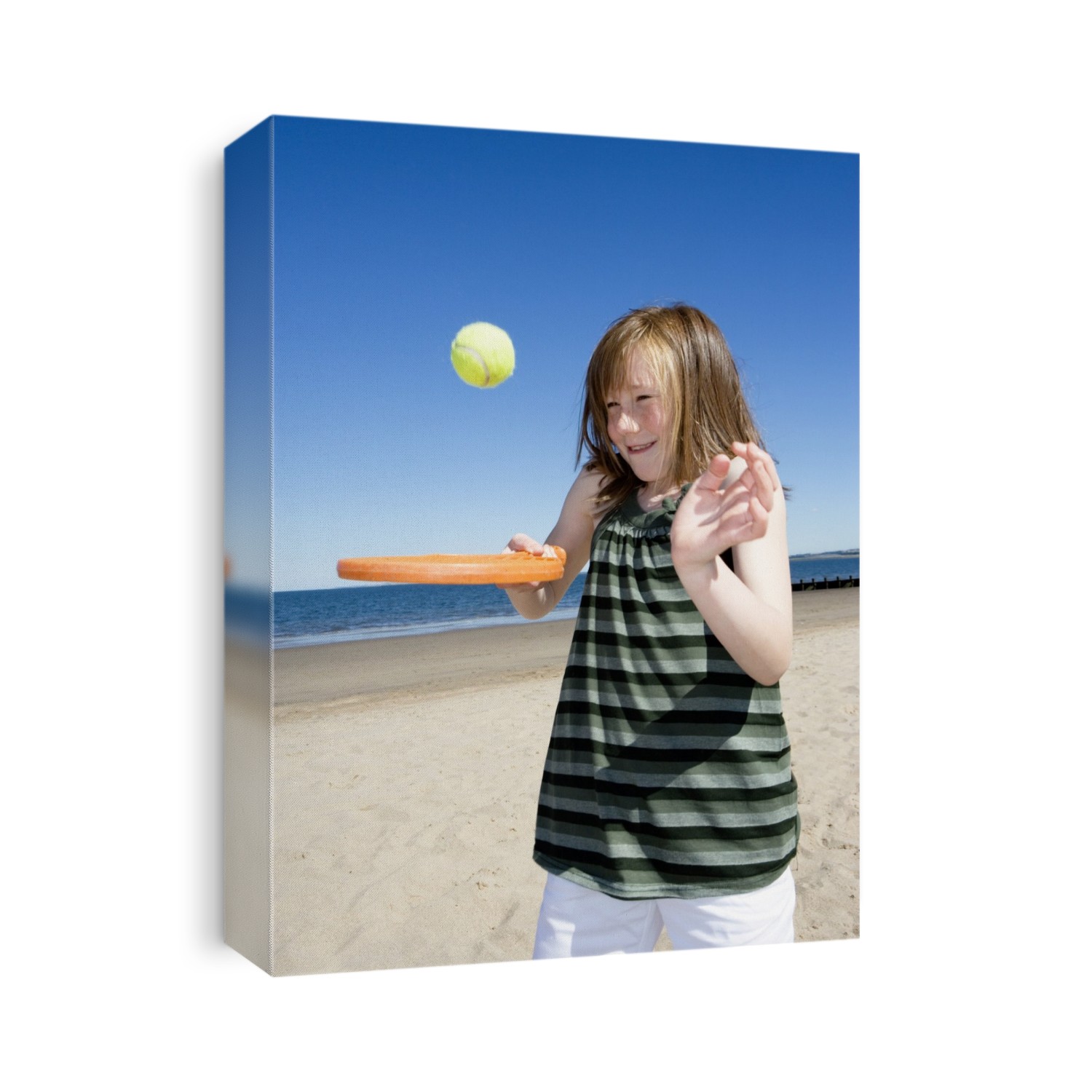 MODEL RELEASED. Girl playing with a bat and ball at a beach.
